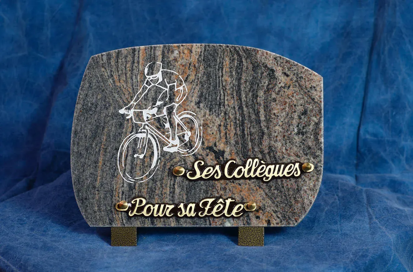 Plaque funéraire en granit gravée d'un motif de cycliste.