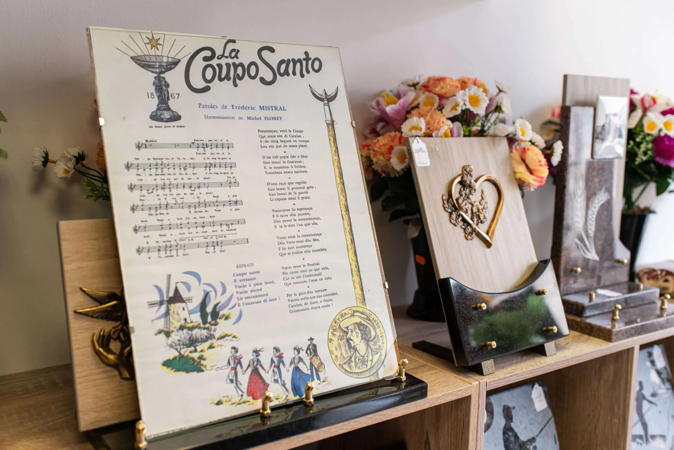 Plaque funéraire personnalisée "Coupo Santo" exposée en magasin.