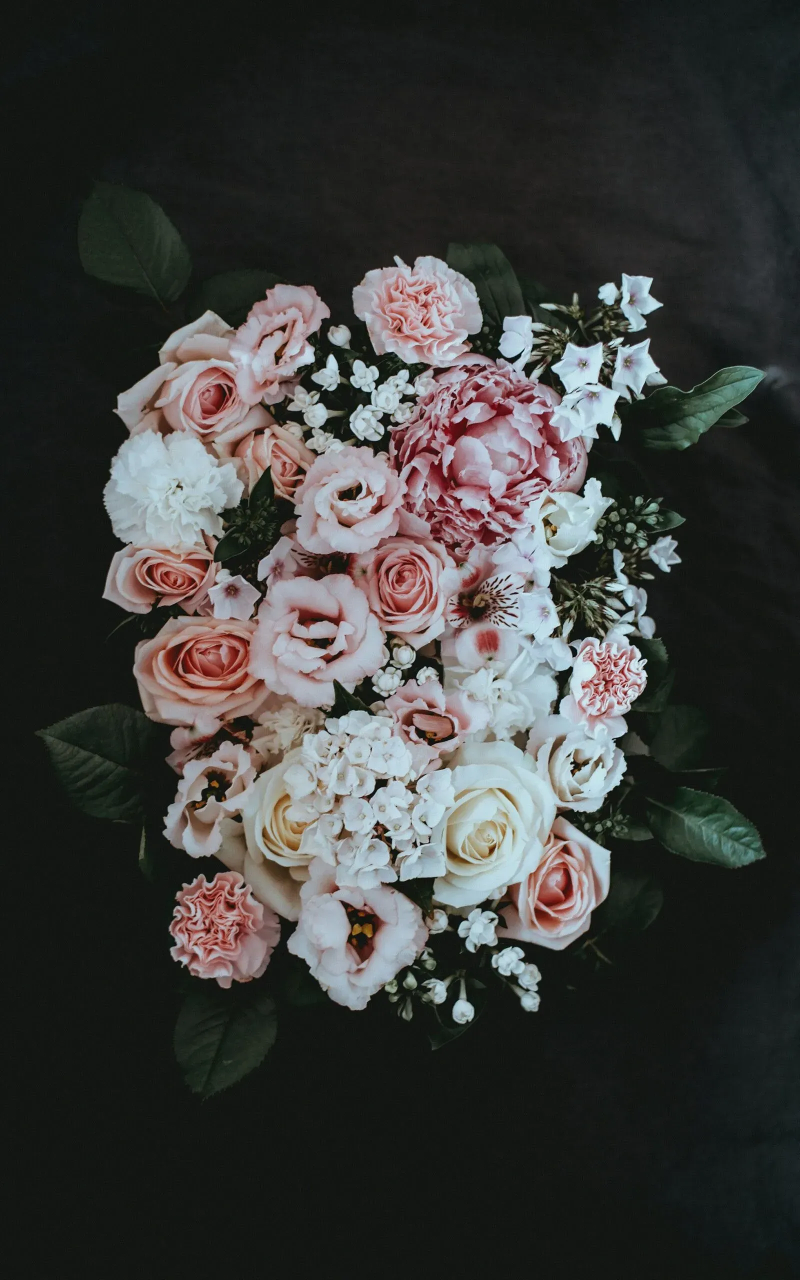 Composition élégante de pivoines, roses et fleurs en tons poudrés.
